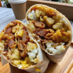 Delicious Easy Breakfast Burritos filled with scrambled eggs, sausage, cheese, and crispy hashbrowns, served on a plate.