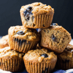 Freshly baked Blueberry Zucchini Muffins cooling on a wire rack with visible blueberries and golden tops.