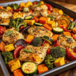 Sheet Pan Chicken with Rainbow Vegetables roasted to golden perfection, with chicken, sweet potatoes, broccoli, zucchini, yellow squash, and red bell pepper.