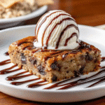 A freshly baked One Bowl Banana Chocolate Chip Snack Cake, cut into squares with gooey chocolate chips visible.