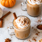 A steaming cup of Homemade Pumpkin Spice Latte topped with whipped cream and a sprinkle of pumpkin pie spice.