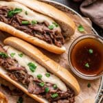Slow Cooker French Dip Sandwiches with melted cheese and au jus ready to serve