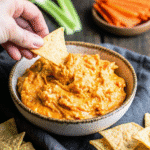 Crock Pot Buffalo Chicken Dip served in a slow cooker with tortilla chips on the side.