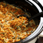 Crock Pot Green Bean Casserole in a slow cooker topped with golden crispy onions