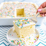 A freshly baked One Bowl Vanilla Sheet Cake cooling on a wire rack, golden and fluffy.