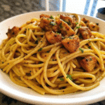 A skillet of Cowboy Butter Chicken Linguine with creamy sauce, tender chicken pieces, and garnished with fresh parsley.