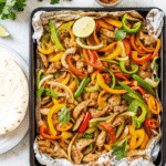 Sheet Pan Fajita Chicken and Potatoes with colorful bell peppers, onions, and seasoned chicken ready to serve in warm tortillas.