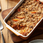 Golden brown Sweet Potato Casserole topped with a crunchy pecan and brown sugar crumble in a baking dish.
