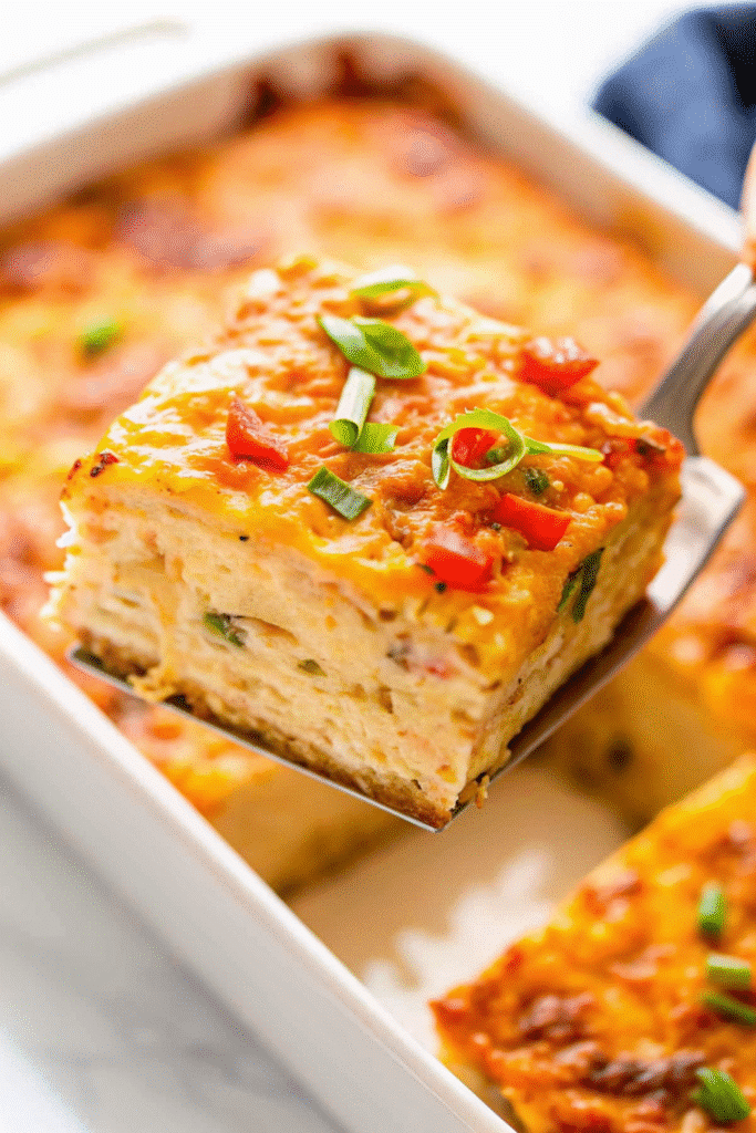Slices of Christmas Brunch Casserole served on a plate, showing layers of bacon, mushrooms, hash browns, and melted cheese.