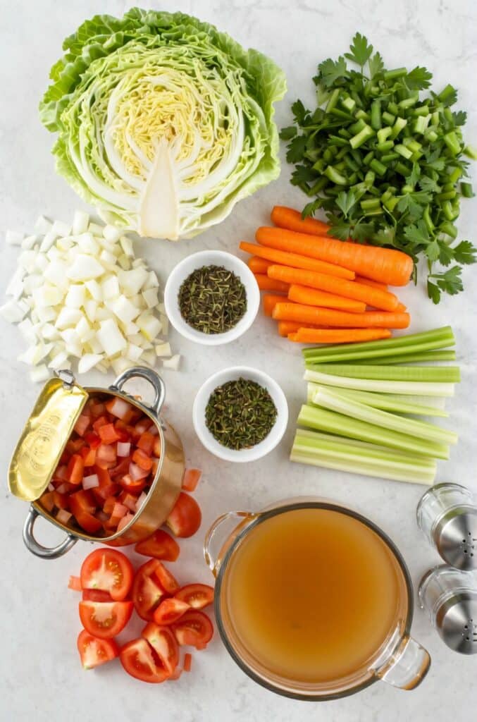 Fresh ingredients for Weight Watchers Cabbage Soup laid out on a kitchen counter.