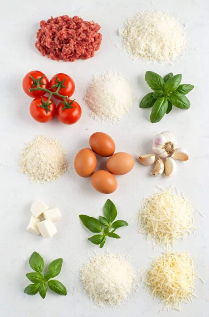 Ingredients for Christmas meatballs laid out on a kitchen counter, including ground beef, pork, breadcrumbs, eggs, onion, garlic, and spices.