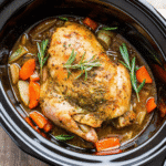 Crockpot Turkey Breast cooked with garlic, herbs, and onions, ready to serve on a platter.