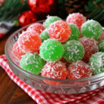 Colorful red and green Christmas Jello Balls coated in coconut, arranged on a festive holiday tray.