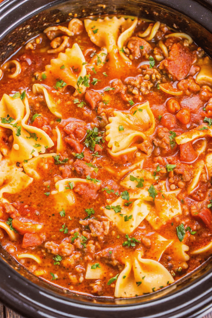 Crock Pot Lasagna Soup Recipe 3 Slow cooker lasagna soup served in a white bowl with Parmesan cheese and fresh herbs on top
