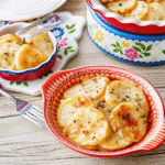 Creamy crock pot scalloped potatoes layered with sliced russet potatoes, onions, and melted cheese in a slow cooker.