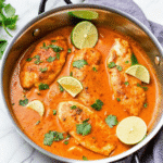 Creamy Coconut Lime Chicken served in a skillet garnished with fresh cilantro and lime wedges.