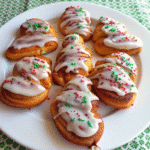 Warm Christmas Cinnamon Rolls with gooey cinnamon-sugar swirls topped with brown butter caramel cream cheese icing in a baking dish