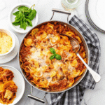 Skillet Lasagna Recipe topped with melted mozzarella and fresh basil served in a cast iron pan.