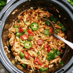 Slow-cooked shredded chicken in a crock pot with salsa and spices, ready for tacos or bowls.