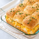 baking dish filled with golden-baked Crack Chicken Sliders topped with melted cheddar, parmesan, and chopped chives.