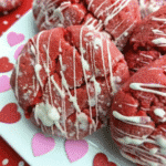 Freshly baked Valentine day white chocolate crinkle cookies coated in powdered sugar on a cooling rack
