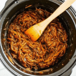 CrockPot Pulled BBQ Chicken shredded on a bun with rich BBQ sauce