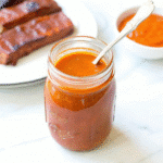 Bacon Bourbon BBQ Sauce Recipe simmering in a saucepan with visible bacon bits and a rich, glossy texture