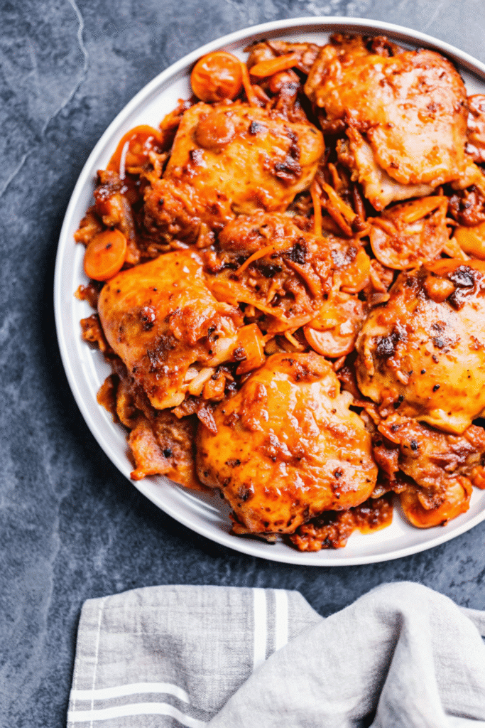 Plate of golden-brown Instant Pot chicken thighs with garlic and herbs, served ready to eat.