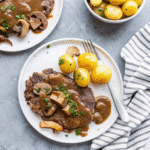 Tender Instant Pot Cube Steak with baby potatoes, cremini mushrooms, and onions in savory beef broth