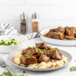 Slow Cooker Beef Tips with tender beef cubes, mushrooms, onions, and rich savory gravy served in a bowl.