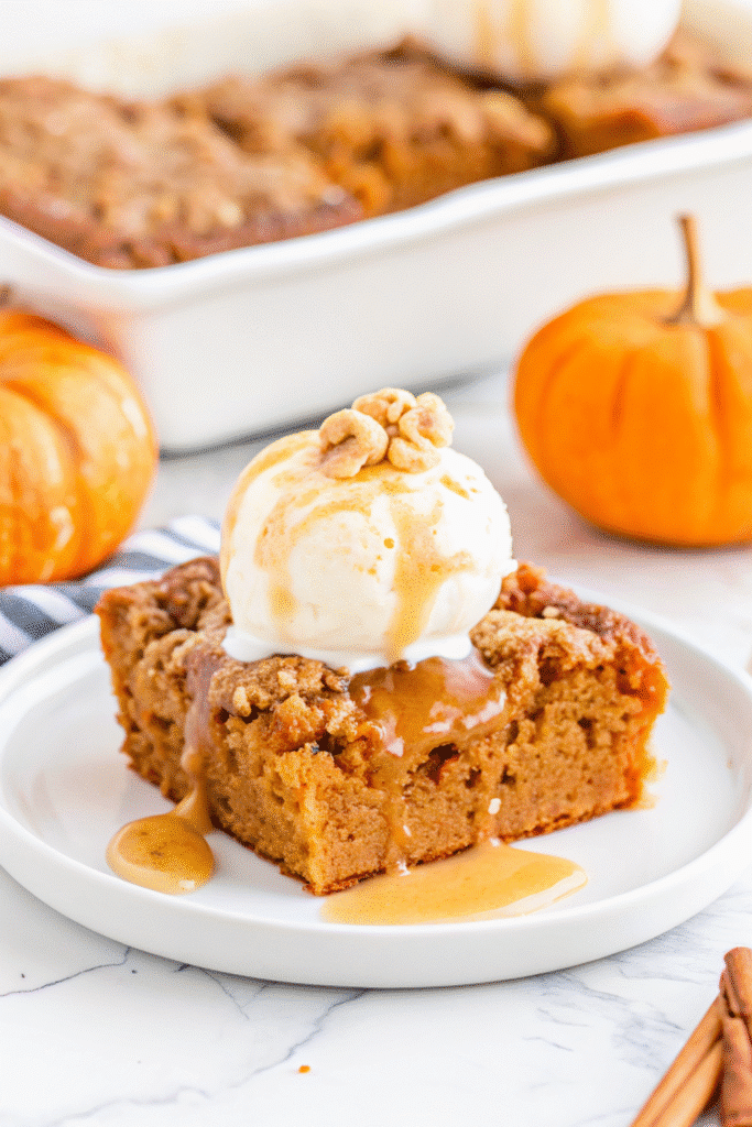 Christmas Pumpkin Dump Cake Recipe 3 Slice of Pumpkin Dump Cake served with whipped cream, showing moist pumpkin base and crisp cake layer