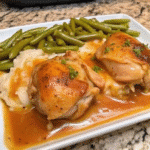 Crockpot Smothered Chicken Legs served with creamy gravy and garnished with fresh parsley