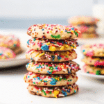 A plate of freshly baked Rainbow Sprinkle Cookies with colorful nonpareils on top, showcasing soft, chewy texture.