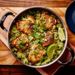 Golden-brown chicken thighs cooked in a single pot with rice, black beans, and fresh cilantro.