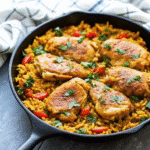 One Pot Low FODMAP Chicken and Rice served in a skillet with vibrant bell peppers and spinach