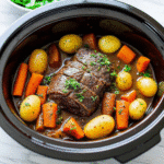 Slow Cooker Garlic Herb Pot Roast with carrots, potatoes, and fresh herbs