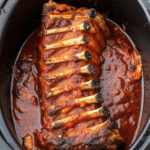 Tender slow cooker baby back ribs glazed with rich BBQ sauce on a serving plate