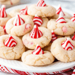 Freshly baked Candy Cane Kiss Cookies with crushed candy canes and chocolate kisses in the center, arranged on a festive tray.