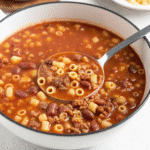 Bowl of homemade Olive Garden Pasta e Fagioli soup with ditalini pasta, beans, tomatoes, and fresh herbs.