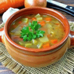 A steaming bowl of Instant Pot Cabbage Soup with colorful vegetables including carrots, celery, and cabbage, served in a white bowl.