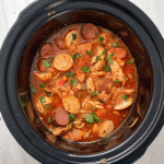Crockpot Spicy Chicken and Sausage Recipe with shredded chicken, sliced sausage, peppers, and tomatoes in rich sauce