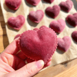 Heart-shaped Valentine Ravioli made with pink beet pasta, filled with ricotta and parmesan, served with butter and crispy sage