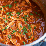 Instant Pot Mexican Shredded Chicken Thighs served in a bowl, garnished with fresh cilantro