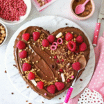 Valentines Brownies topped with dark chocolate ganache, fresh raspberries, and festive sprinkles