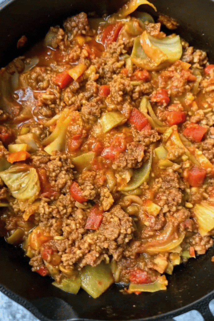 Close-up of Crock Pot Unstuffed Cabbage Rolls simmering in a flavorful tomato-based sauce.