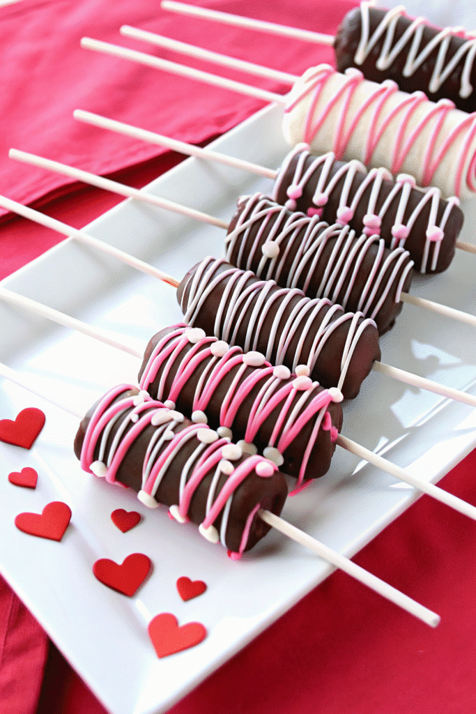 Handmade Valentine Marshmallow Pops dipped in smooth milk chocolate, topped with sprinkles and pink and red candy wafers.