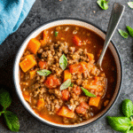 A bowl of Italian Style Instant Pot Beef Chili garnished with fresh basil and grated parmesan.