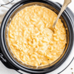 Creamy Crock Pot Mac and Cheese with melted cheddar and Velveeta, served in a white slow cooker.