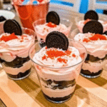 Valentine Dirt Cake Parfaits layered with crushed Oreos, creamy pudding, and fluffy cream topping in clear glasses