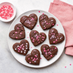 Fudgy Valentine Brownies topped with chocolate chips and festive sprinkles in a baking pan